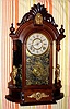 Ansonia Clock Company, Ansonia Conn. "TRIUMPH" model, 8-day brass time and strike mvt in black walnut mirror-sided case flanked by two cupids shelf clock, spring driven. C. 1880.