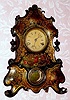 American Clock Co (?), Cast Iron Front shelf clock with gold stenciling with painted flowers below dial, 1-day, spring. C.1860.