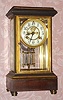 Waterbury Clock Co., FLANDERS, mahogany and brass crystal regulator, with open escapement on the dial and with 2-jar pendulum, and with cast gilt bezel. C.1906.
