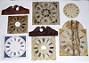Box lot of 15 wooden dials in various conditions. Two modern eagle splats for wooden movement shelf clocks. A modern striking banjo dial, 1 modern replacement glass for an OG or column clock. Period metal dial. ST tall clock dial, distressed but restorable.