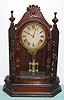 Ansonia Clock Co., 8-day time and bell strike, walnut mantel clock, fancy with pierced sides. Circa 1874. We could not find this model in the catalog, but a similar example: "The Turret" can be found there.