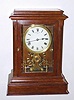 English, EUREKA battery powered mantel clock serial No. 7085, in an oak case, the front door glazed with beveled glass and revealing the large balance wheel, C.1915