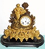 German, Lenzkirch, Cast /gilt mantel clock of a young farmer In Sunday clothes + his basket of roses, 8-day bell strike, serial No. 263496, with a period dome and base. C.1863