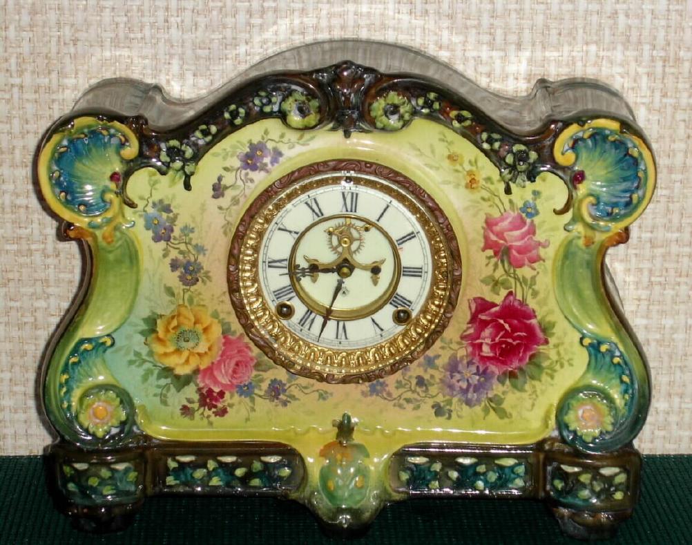 Ansonia Clock Co., C.1915, Royal Bonn, "LA VERGNE" porcelain china cased clock, with 8-day, gong strike mov't with open escapement on porcelain dial, in a multi-colored case, dark green, aqua and yellow with multi colored floral decorations. — Antique Clocks Price Guide