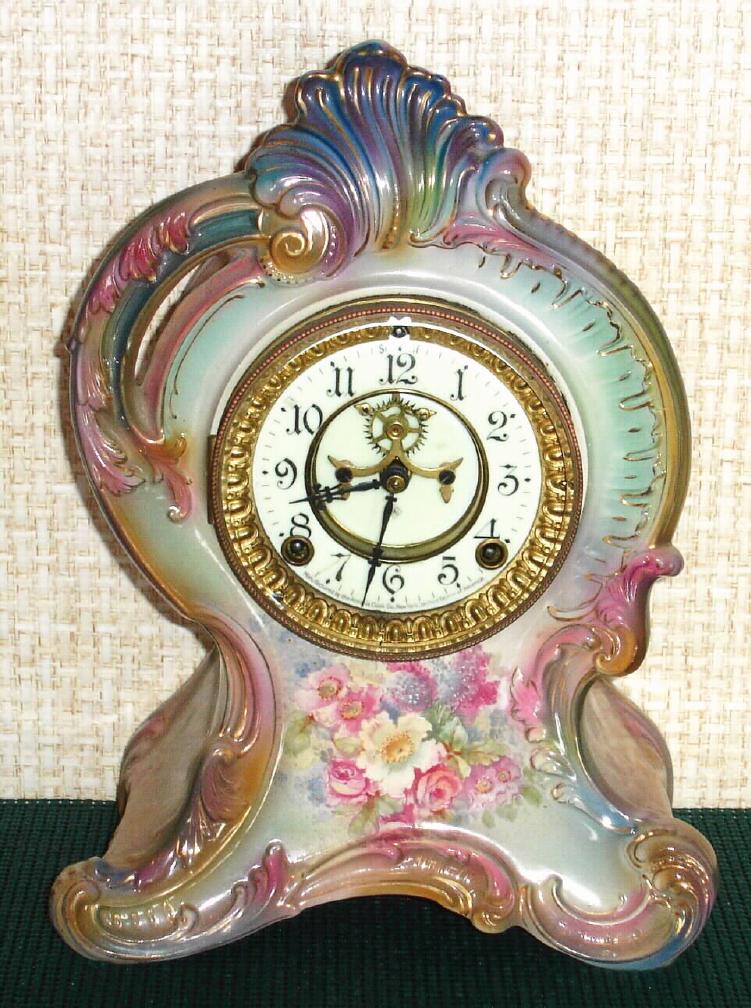 Ansonia Clock Co., C.1915, Royal Bonn, "LA FRANCE" porcelain china cased clock, with 8-day, gong strike mov't with open escapement on porcelain dial, in a multi-colored case, gray, blue and light aqua w/ pink accents, with multi colored floral decorations. — Antique Clocks Price Guide
