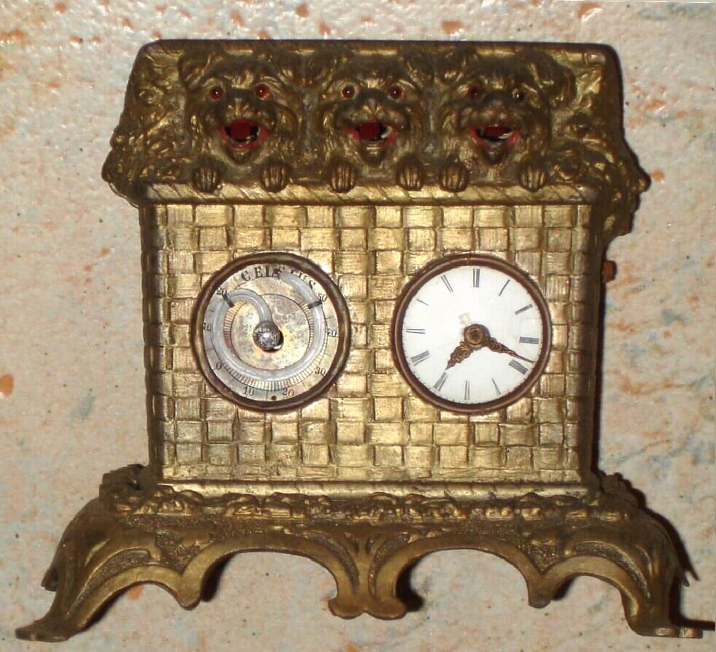 German, Meyer, 'THREE DOGS IN BASKET', all panting with tongues moving in and out with each tick, a small one day pendulum clock on the right side and a thermometer to the left. — Antique Clocks Price Guide