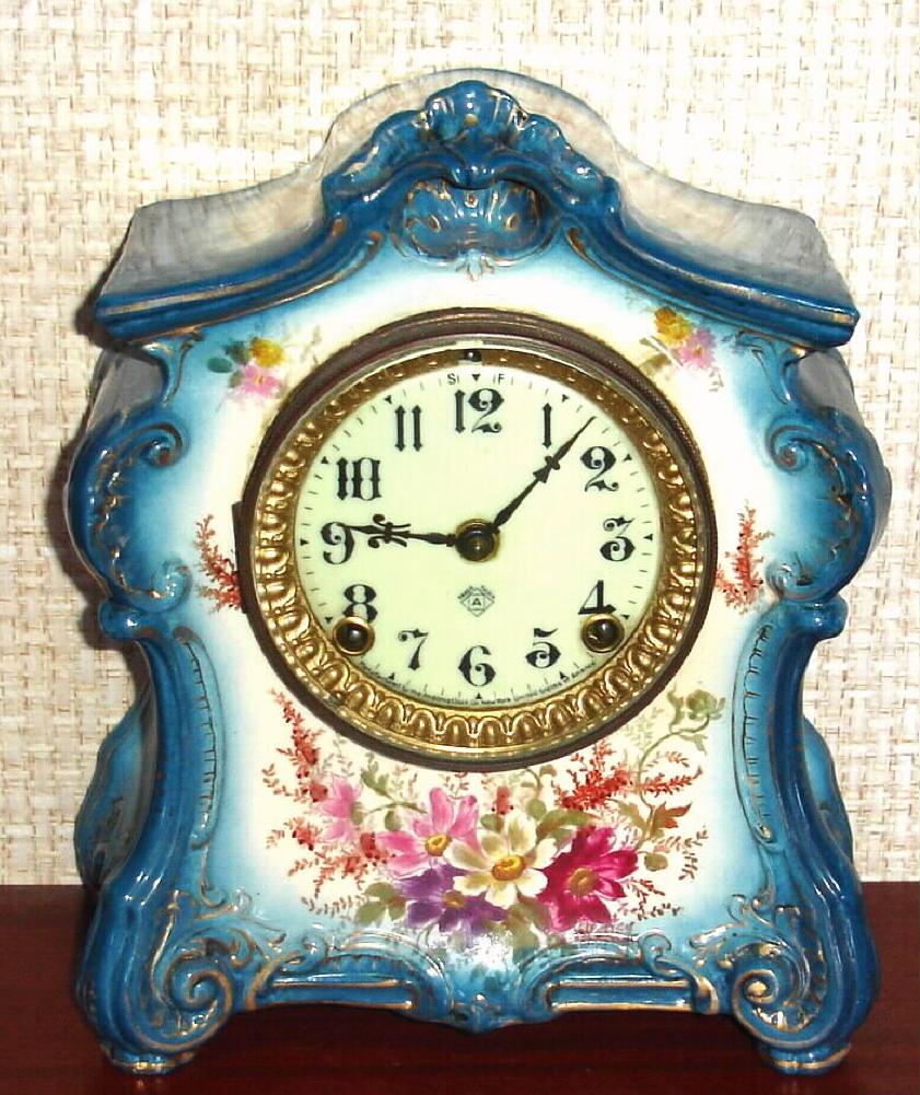 Ansonia Clock Co., C.1914, Royal Bonn, "LA FONTAINE" porcelain china cased clock, with 8-day, gong strike mov't with one piece porcelain dial, in a cream and blue case with multi colored floral decorations, — Antique Clocks Price Guide
