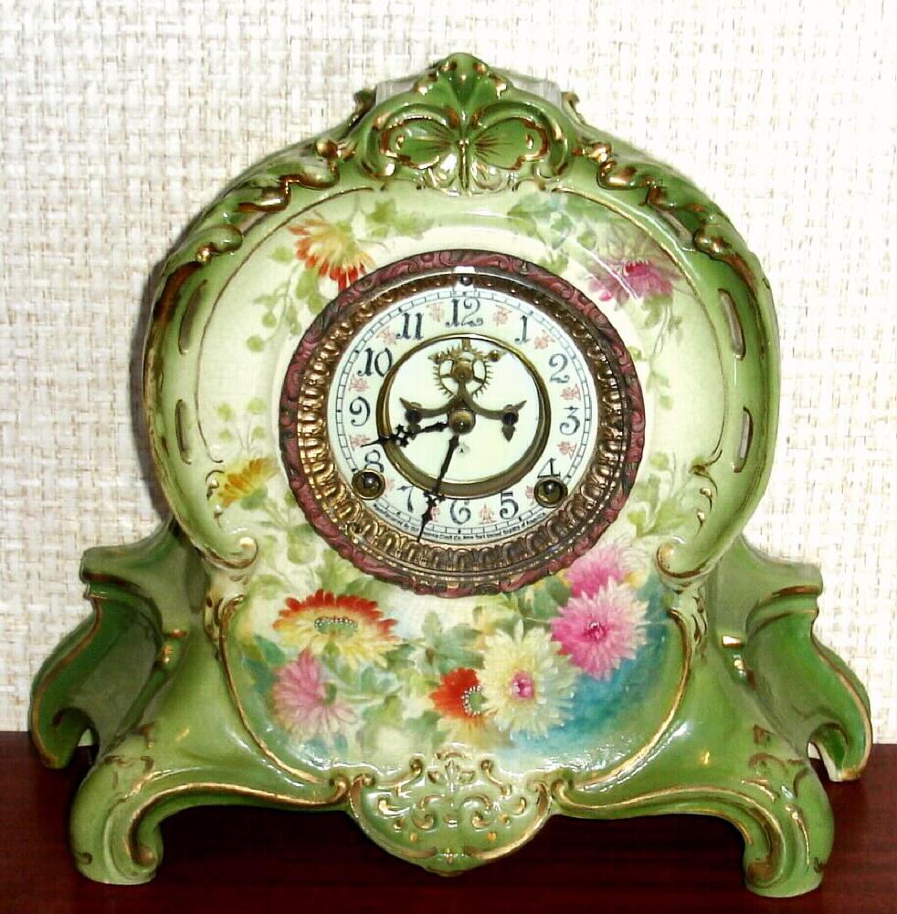 Ansonia Clock Co., C.1905, Royal Bonn, "LA RIVIERE" porcelain china cased clock, with 8-day, gong strike mov't with open escapement on porcelain dial, in a light green case with multi colored floral decorations. — Antique Clocks Price Guide