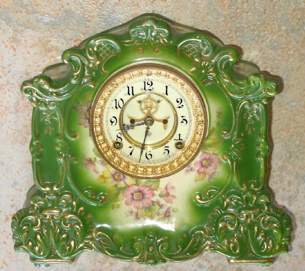 Ansonia Clock Co., C.1905, standard line "RAINBOW" porcelain china cased clock, with 8-day, gong strike mov't with open escapement on porcelain dial, in a medium green case, with multi color floral transfers to the front and sides. — Antique Clocks Price Guide