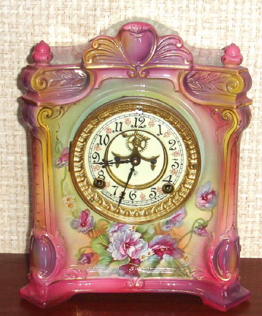 Ansonia Clock Co., C.1915, Royal Bonn, "LA SEINE" porcelain china cased clock, with 8-day, gong strike mov't with open escapement on porcelain dial, in a multi-colored pastel case in shades of pink, violet and blue, and with varied floral decorations to the front and sides. — Antique Clocks Price Guide