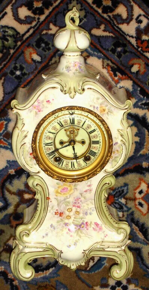 Ansonia Clock Co., C.1895, unknown model, porcelain china clock, all original with premium round movement w/ rack striking, and retaining original Ansonia pine base board and iron gong. Fancy multi color dial. — Antique Clocks Price Guide