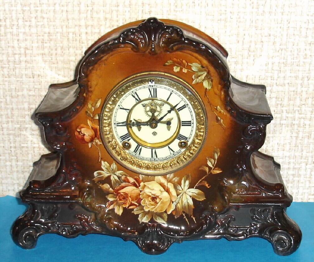 Ansonia Clock Co., C.1900, Royal Bonn, "LA NORD" porcelain china cased clock, with 8-day, gong strike mov't, and open escapement on the dial, case of dark and light brown shades and with tan colored blossoms. — Antique Clocks Price Guide