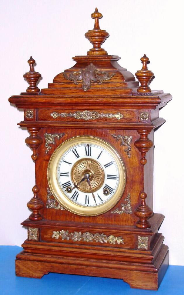 Ansonia Clock Co., "CABINET-A", in oak with brass trimmings, and with old finish. 8-day gong strike movement. — Antique Clocks Price Guide