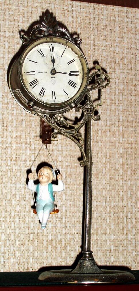 Ansonia Clock Co. New York, "JUMPER NO. 1", C.1896, movement held aloft by a single pole, nickel plated stand, the pin pallet movement released by the ceramic doll jumping up and down. Repro doll with blue vest.. — Antique Clocks Price Guide