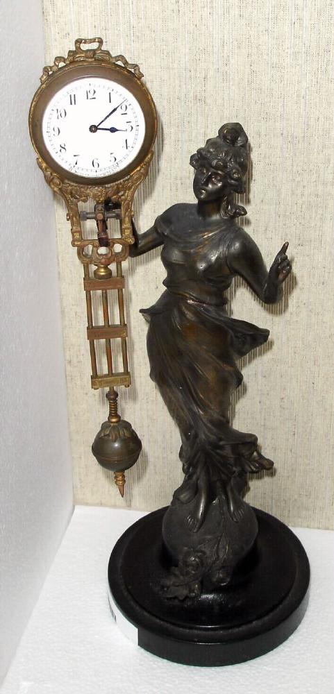 German, Junghans, C.1910, "DIANA" swinging arm novelty, 8-day, time. The patinated spelter statue is affixed to a turned wooden base, and a small, well made movement is housed in the top of the 'clock arm'. — Antique Clocks Price Guide