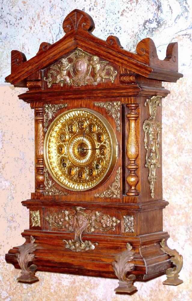 Ansonia Clock Co., New York, C.1894 "CABINET - C", antique oak cased mantle clock with brass trimmings. Has fancy embossed brass dial with raised Arabic numerals, — Antique Clocks Price Guide