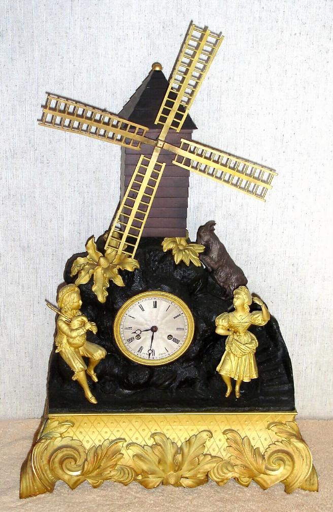 French, Automaton Figural clock, the dial marked LeRoy, Paris, with a windmill powered by a separate movement in the base, and a bag-piper piping while a costumed girl to the right is dancing, and behind a silvered goat is eating flowers, C.1880 — Antique Clocks Price Guide
