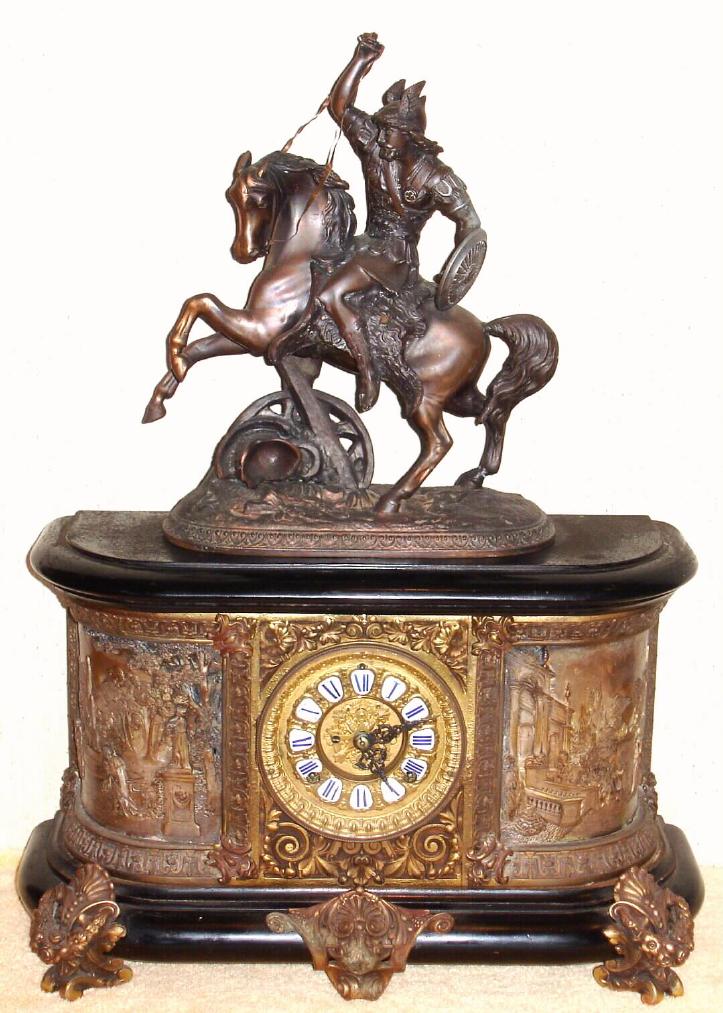 Ansonia Clock Co., New York, C.1904, "VIRGINIA and DAGOBERT" figural clock, base with fancy cast brass dial, open 'scape, and with individual cartouche number plaques {royal blue Roman numerals}, 8-day, gong strike. — Antique Clocks Price Guide