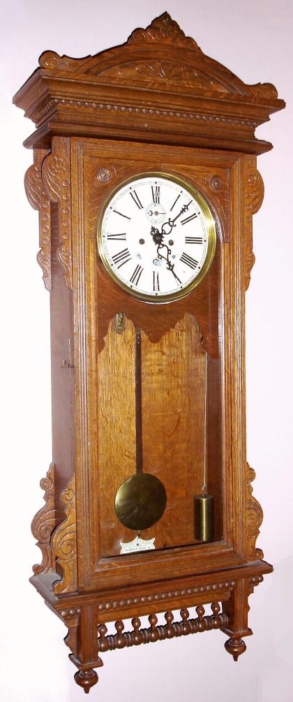 Waterbury Clock Co., "REGULATOR No. 57", C.1906, quartered oak cased. 2-weight time only wall clock, 8-day with seconds hand below 12. — Antique Clocks Price Guide