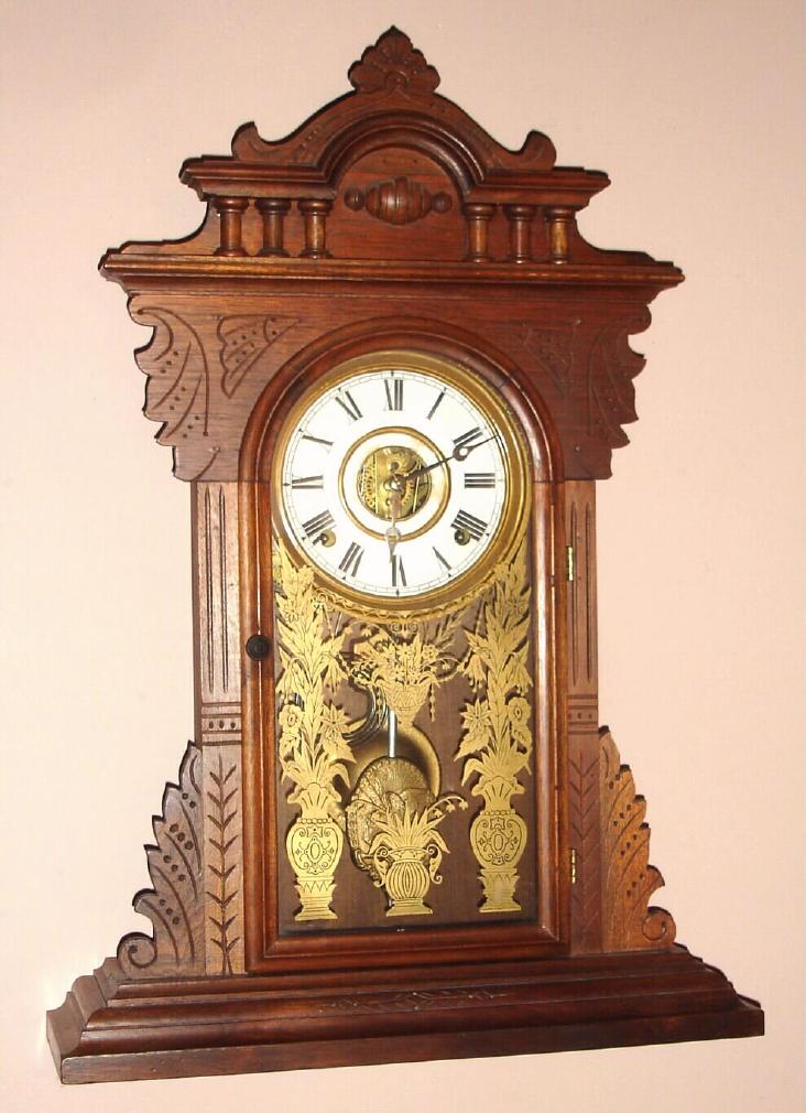 E.N. Welch, Forestville, Conn. gingerbread clock 8 day time and strike spring driven mvt in walnut case with Roman numeral paper over gilt dial, c1890 — Antique Clocks Price Guide
