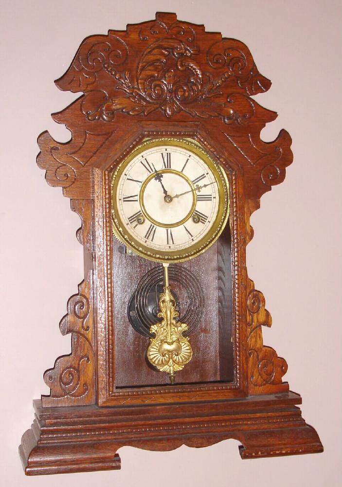 Waterbury Clock Co., Waterbury Conn. "KELSO" gingerbread clock with 8 day time and strike on gong spring driven mvt in oak case with Rococo style 6" paper over gilt pan dial, c1891 — Antique Clocks Price Guide
