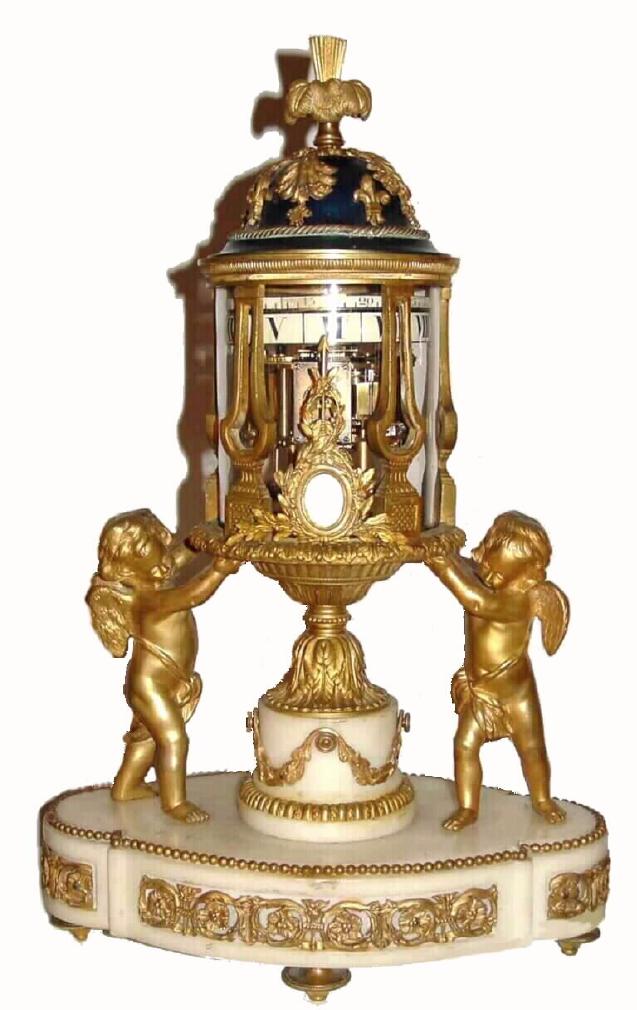 French, Ormolu and White Marble Temple motif clock with revolving annular dials, C.1875. The bell striking movement with platform lever escapement, driving two porcelain cartouche time rings, top minutes and bottom - hours, and in excellent original condition. The movement sets in a glass surrounded temple with ormolu plume filial, on a leaf cast pediment, and supported from either side by a gilt winged putti, all on an oval white base with inset floral ormolu friezes and gilded feet. — Antique Clocks Price Guide