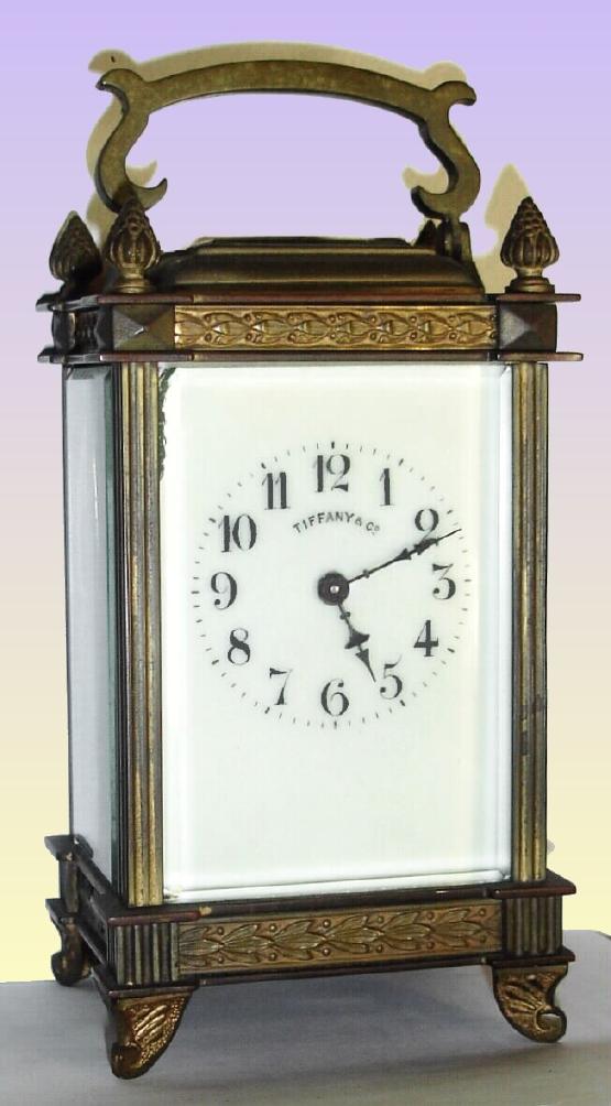 French for Tiffany, Carriage Timepiece, c.1900, in an unusual brass case with reeded columns, cast French feet, pineapple finials and bands of acanthus leaves around top and bottom. — Antique Clocks Price Guide