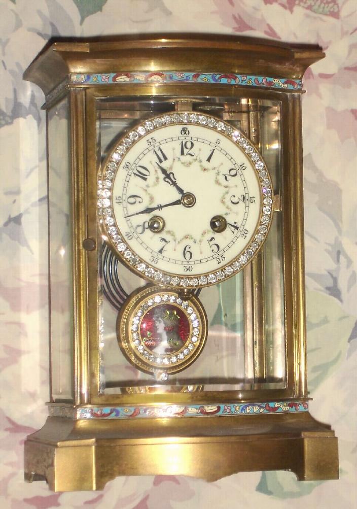 French, Bow front brass and glass, with enamel Portrait pendulum and brilliant dial and pend surround, c.1900, 8-day, gong strike. Case has full bands of multi color enamel decorations top and bottom. — Antique Clocks Price Guide