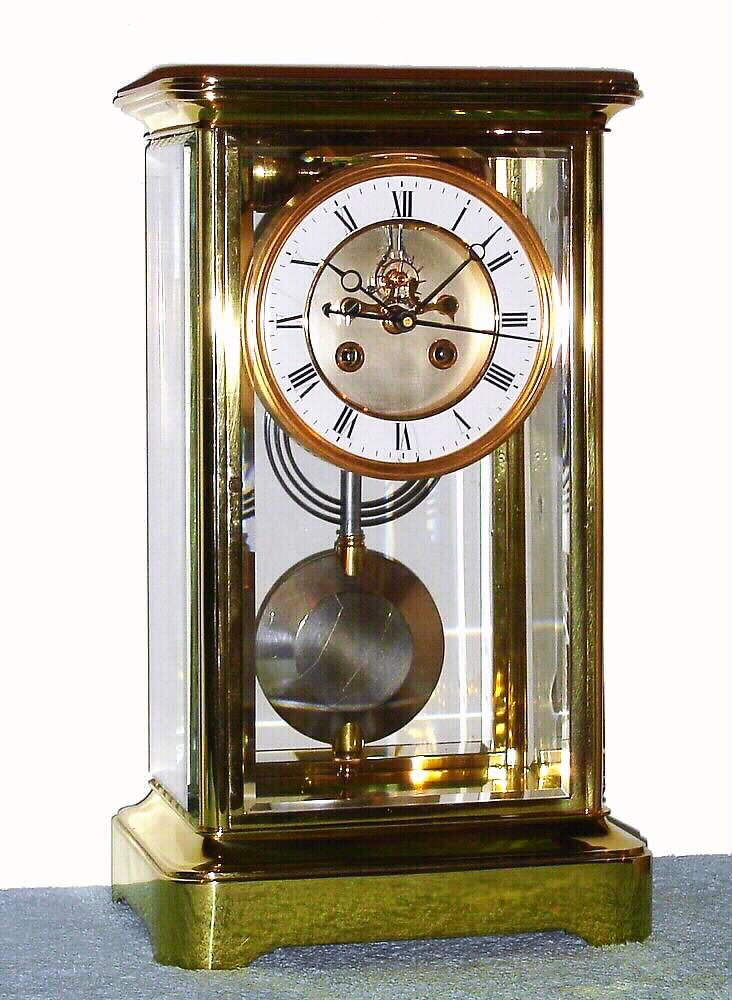 J. Marti and Cie., for Guilmet, crystal regulator 8 day time and strike, with a form of Desfontaines escapement exposed on the dial center, patented 1854, with sweep second's hand, Roman numeral porcelain chapter ring and compound pendulum, c1885. This type of modified Desfontaines escapement is a form of coup perdu (lost beat) escapement that allows for a sweep second's hand to indicate true seconds from a half second's beating pendulum, with the added advantage of constant force impulsing the pendulum — Antique Clocks Price Guide