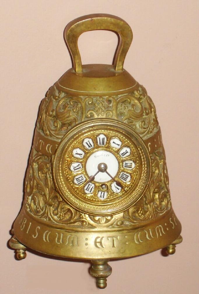 French for Maple and Co., London [on dial], miniature bell timepiece, cast of heavy brass, showing in relief several Christian tenants, and with cast angels all around, each playing a different musical instrument. This is the smallest version of the "Pater Noster" clock, note there is a porcelain china one selling in earlier session. — Antique Clocks Price Guide