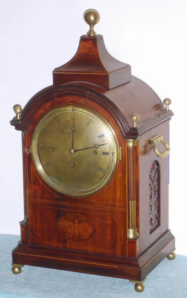 European, for Camerden and Forster, NY, classic English Regency styled bracket clock, 3-train, Westminster chime on 4 enormous coiled flat wire gongs, in a mahogany case with reeded quarter columns, brass capitals and stop fluting, C.1900 {in the style of 80 years earlier}. Strikes the hours on an even larger coiled gong. — Antique Clocks Price Guide