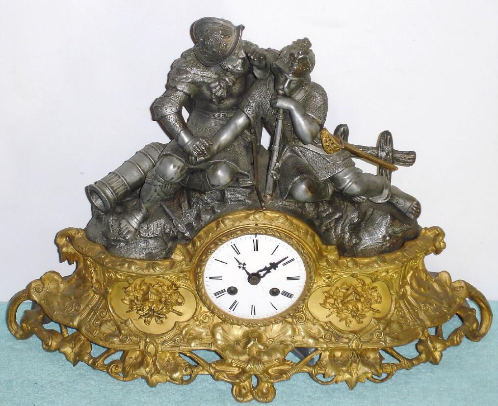 French, cast metal figural clock with a gilt base, two 17th century combatants, clothed in chain mail, resting between battles, with a silk-thread, bell strike movement. — Antique Clocks Price Guide