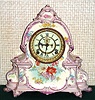 Ansonia Clock Co., C.1904, Royal Bonn, "LA MANCHE" porcelain china cased clock, with 8-day, gong strike mov't with open escapement on porcelain dial. Case a very light violet shade, and with floral decorations to the sides.