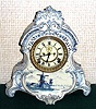 Ansonia Clock Co., C.1905, Royal Bonn, "LA NORMANDIE" porcelain china cased clock, with 8-day, gong strike mov't with open escapement on porcelain dial, in a Blue Delft case with windmills and sailing ships.