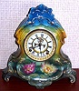 Ansonia Clock Co., C.1905, Royal Bonn, "LA NORMANDIE" porcelain china cased clock, with 8-day, gong strike mov't with open escapement on porcelain dial, in a TRI-colored case, aqua/green top, yellow center + dark green at base, with pink and yellow water lily blossoms below the dial.