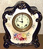 Ansonia Clock Co., C.1905, Royal Bonn, "LA MURE" porcelain china cased clock, with 8-day, gong strike mov't with one piece porcelain dial, the case in dark cobalt blue with gold highlights and floral decorations.