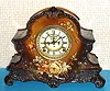 Ansonia Clock Co., C.1900, Royal Bonn, "LA NORD" porcelain china cased clock, with 8-day, gong strike mov't, and open escapement on the dial, case of dark and light brown shades and with tan colored blossoms.