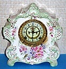Ansonia Clock Co., Royal Bonn, "LA VOGUE", porcelain clock in the French style, with open escapement on porcelain dial, the creamy case with very light green accents and gold highlights and multi color floral paintings, c1900