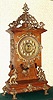 Ansonia Clock Co., New York, "CABINET - D" antique oak finished mantel clock with brass trimmings, this model with "open well" design to show the fancy cast pendulum w/ sun burst face in center. Fancy brass dial is embossed with numerals on raised circles, c.1894