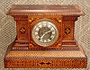 Ansonia Clock Co., New York, movement in a custom made parquetry case with the finest hounds tooth detail. 8-day, strike, C.1900. Note this movement is Ansonia's best round French style with rack striking and fancy brass dial with cartouche numerals and open escapement with eagle head support for top pivot.