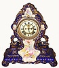 Ansonia Clock Co., C.1910, Royal Bonn, "LA CERDA" porcelain china cased clock, Cobalt Blue, with 8-day, gong strike mov't with open escapement on porcelain dial, with a hand painted blossoms in pastel colors, the entire case with profuse gold highlights. Bonn trademark on rear in gold.