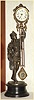 Ansonia Clock Co. New York, C.1896, "FISHER" canister swing clock (3" dial), on deep iron base. Note cast figure hold the clock arm aloft, and the entire arm swings without apparent impulse.