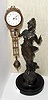German, Junghans, C.1910, "DIANA" swinging arm novelty, 8-day, time. The patinated spelter statue is affixed to a turned wooden base, and a small, well made movement is housed in the top of the 'clock arm'.