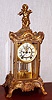 Ansonia Clock Co., New York, C.1910, "EULOGY", 4-Glass crystal regulator, surmounted by a winged cherub playing a flute. With 8-day gong strike movement with open escapement on the porcelain dial.