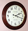 Seth Thomas Clock Co., Thomaston, Conn, "ARCADE" model, round gallery timepiece, with 30-day duplex spring movement, 18" dial, walnut case with bezel hinged above 12.