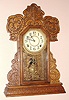 E. Ingraham Co., Bristol Conn. "CAYUGA" model gingerbread clock from Ingraham's Lake Line seried 8 day time and half hour strike spring driven mvt in oak case with Arabic numeral gilt pan 6" dial, c1915
