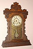 The E. Ingraham Clock Co., Bristol, Conn. "GARNET" model 8 day, time and strike, spring driven mvt in walnut case with "basket weave" pressing and Roman numeral gilt brass dial pan 6" dial, c1895