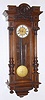 Austrian, Gebruder Resch (Remember), smaller 2-wt, with 5.5" dial, as-found, LESS weights and pulleys. Has rod strike. Walnut case has robust 3/4 columns with heavily carved capitals and a nice carved head in the "built in" top, plus carving on the base.