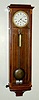 A repro miniature Vienna timepiece in the early Biedermeier style, the case of crotch mahogany with holly banding around the edges and additional inlay. The weight driven movement is a well made copy of a mini original. C.2000,