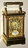 Carriage clock retailed by Bigelow Kennard and Co., Boston with hour repeat and half hour strike 8 day platform lever escapement spring driven movement in Anglais Riche case with two tone Corinthian columns surmounted by rose gold colored fancy capitals with Roman numeral silvered chapter ring surrounded by pierced gilt mask and set on three sides with ivory painted panels of cherub scenes, c1900